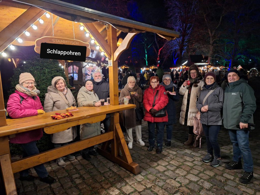 Eine Gruppe der Schlappohren SHG an einem überdachten "Stammtisch" im Luisenpark